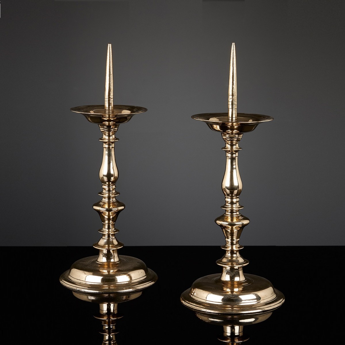 A pair of Baroque 16/17th century brass pricket candlesticks