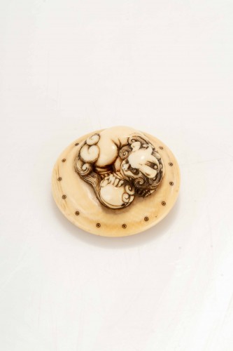 Netsuke en ivoire représentant un Shishi accroupi sur un tambour - Arts d