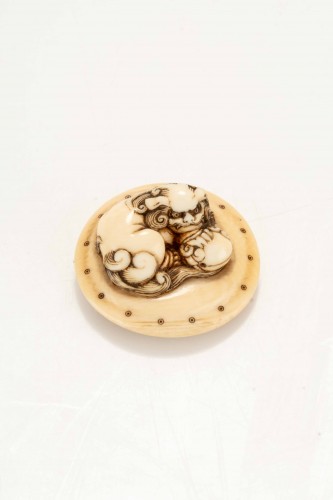 Netsuke en ivoire représentant un Shishi accroupi sur un tambour - Mastromauro Japanese Art