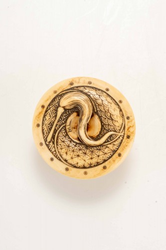 Netsuke en ivoire représentant un Shishi accroupi sur un tambour - 