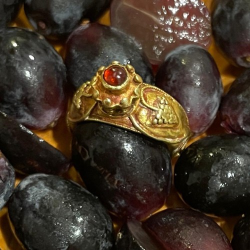 BC to 10th century - Gold ring with grapes and a cabochon garnet. Merovingian, 6th century AD.  