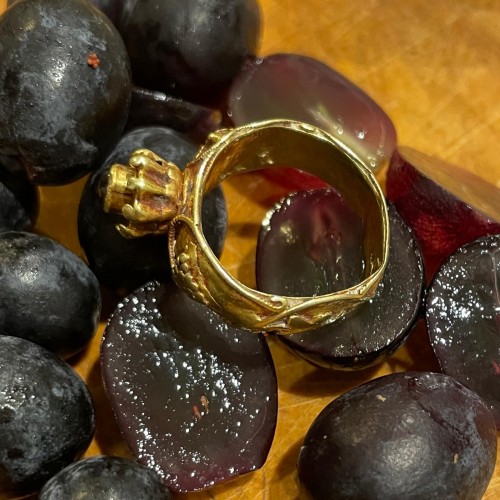 Antiquités - Gold ring with grapes and a cabochon garnet. Merovingian, 6th century AD.  