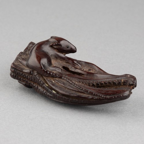 XIXe siècle - Netsuke en bois sculpté, représentant un rat grimpant sur une tête de saumon séché